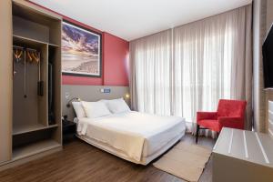 Habitación de hotel con cama y silla roja en Hilton Garden Inn Praia Brava en Itajaí