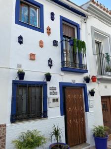 een wit gebouw met blauwe ramen en een deur bij Casita Beatriz - by Casa del Patio in Estepona