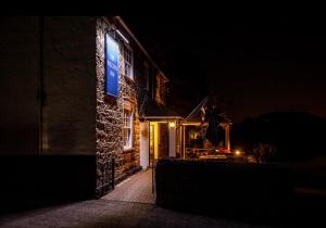 un edificio con una señal azul en su costado por la noche en The Wilcove Inn en Torpoint