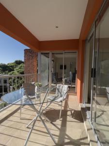 une table et des chaises en verre sur le balcon d'une maison dans l'établissement Orangerie Guest House, à Johannesbourg