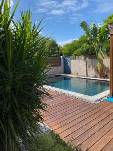 una piscina en una terraza de madera con plantas en Villa HIMANI, en Saint-Gilles-les-Bains