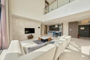 uma sala de estar com mobiliário branco e uma televisão de ecrã plano em Y Collection by UH FLAT Daegu em Daegu