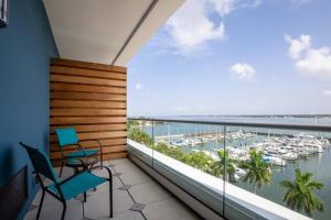 een balkon met 2 stoelen en uitzicht op een jachthaven bij SpringHill Suites by Marriott Bradenton Downtown/Riverfront in Bradenton