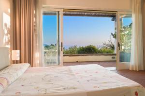 ein Schlafzimmer mit einem großen Bett und einem großen Fenster in der Unterkunft Borgo La Pietraia in Paestum