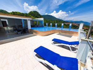 une maison avec une piscine et deux chaises longues bleues dans l'établissement Hermoso Apto - C.C San Gil Plaza, à San Gil