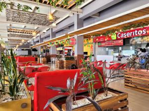 un restaurant avec des chaises rouges et des plantes en pot dans l'établissement Hermoso Apto - C.C San Gil Plaza, à San Gil