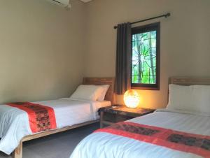 1 dormitorio con 2 camas y vidriera en Villa Jeruk en Selong Belanak