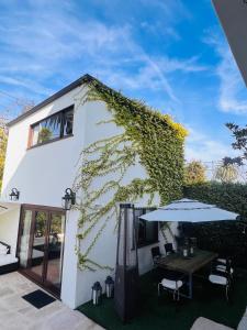 un edificio blanco con una mesa y una sombrilla en The Cozy Villa en Los Ángeles