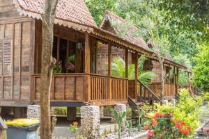 uma casa de madeira na floresta com uma árvore em Jukung Cottage em Nusa Penida