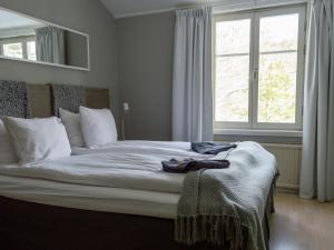 a bedroom with a large white bed with a window at Skeviks Gård in Gustavsberg