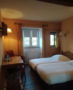 Habitación de hotel con 2 camas, mesa y ventana en Logis Auberge le centre poitou, en Coulombiers