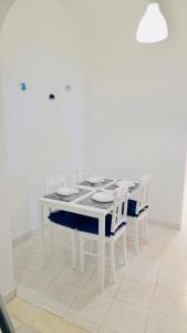 - une table à manger blanche avec des chaises blanches et une table blanche dans l'établissement Casa da Salúquia, à Moura