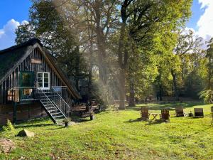 domek z bali na polu trawy z drzewami w obiekcie Stimbekhof w mieście Bispingen