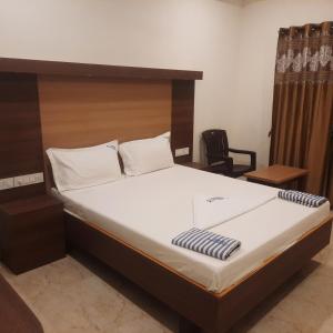 um quarto com uma cama e uma cabeceira em madeira em Rani Residency em Kanyakumari