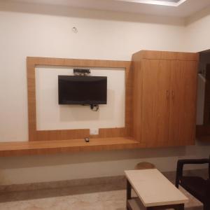 uma sala de estar com uma televisão na parede em Rani Residency em Kanyakumari