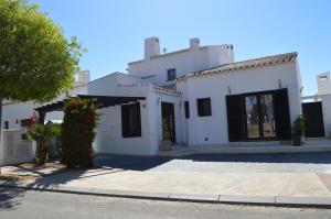 a white house with black windows and a driveway at Villa Vinka - El Valle Golf Resort in Lo Mendigo