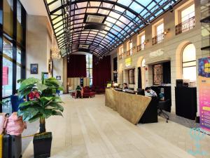 un hall avec des personnes assises sur les bureaux dans un bâtiment dans l'établissement Scarletz Suites KLCC by Mykey Global, à Kuala Lumpur