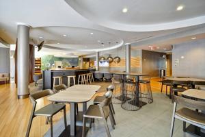 un restaurant avec des tables et des chaises ainsi qu'un bar dans l'établissement SpringHill Suites Tallahassee Central, à Tallahassee