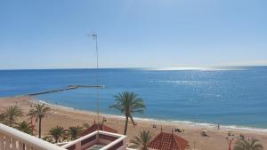 vistas a una playa con palmeras y al océano en Atico Mosean en Vinarós