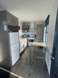 een keuken met een koelkast en een tafel. bij Amberlea Cottages in Hokitika