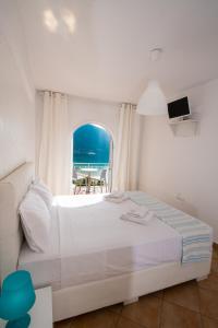 1 dormitorio con cama y vistas al océano en Seaview Rooms en Vasilikí