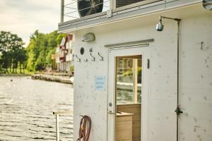 un edificio blanco con una puerta al lado de un cuerpo de agua en Farsund Resort en Farsund