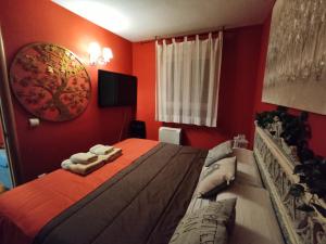 a red bedroom with a bed with towels on it at Apartahotel Rural CollaRubio Luxury in Collado Mediano