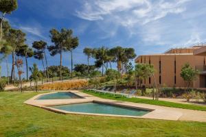 a swimming pool in the grass in front of a building at Palmares Signature Apartments in Lagos