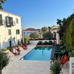 einen Pool mit Liegestühlen und ein Gebäude in der Unterkunft Yayaki Spetses in Spetses