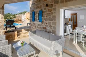 a living room with a couch and a stone wall at Villa Starry Sky ,Hvar in Jelsa