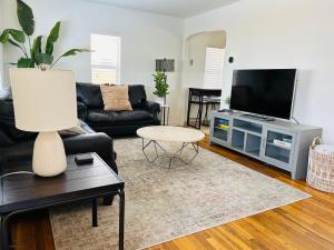 sala de estar con sofá negro y TV en Home Sweet Idahome, feels like home with all the decor you wish you could afford King bed in master, fully fenced dog friendly yard, a few blocks from BSU and downtown Boise, Your perfect stay! en Boise