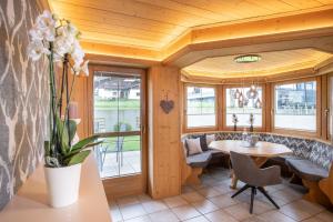 comedor con mesa, sillas y ventanas en Romantik Ferienwohnungen en Pertisau