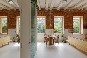 Habitación con mesa, sillas y ventanas. en Loft Apartment en Ivano-Frankivsk