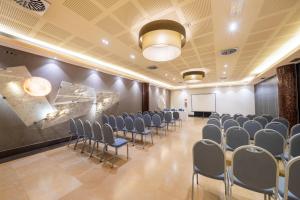 uma sala de conferências com cadeiras e um quadro branco em Iberik Santo Domingo Plaza Hotel em Oviedo