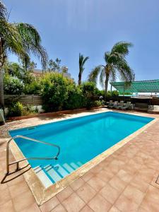 una piscina en un patio con palmeras en Sea View Villa in Agia Thekla, en Ayia Napa