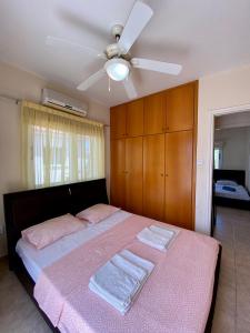 1 dormitorio con 1 cama y ventilador de techo en Sea View Villa in Agia Thekla, en Ayia Napa