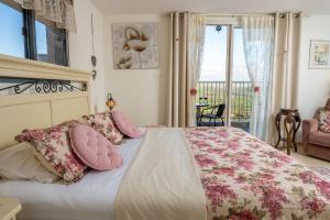 ein Schlafzimmer mit einem Bett mit rosa Kissen und einem Balkon in der Unterkunft Suite Kolibri in Galilee in Semadar