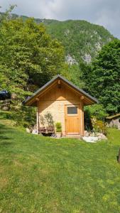 a cabin with a wooden door in a field of grass at U KONC in Stahovica