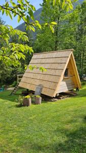 een kleine hut met een dak in een grasveld bij U KONC in Stahovica