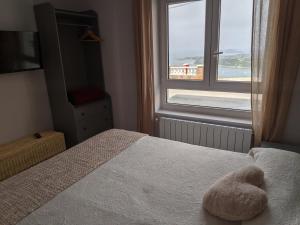 una camera da letto con un letto e un animale di peluche di LA CASA DE VIOLETA a Suances