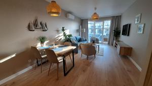 ein Wohnzimmer mit einem Tisch, Stühlen und einem Sofa in der Unterkunft Apartament z widokiem Dziwnów & Spa, in Dziwnów