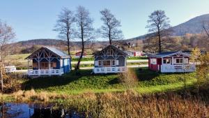 um grupo de chalés num campo junto a um lago em Osada Pstrąga em Stronie Śląskie