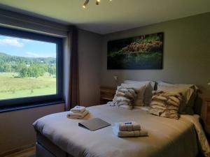 een slaapkamer met een groot bed en handdoeken bij Q-time Barvaux, Durbuy-Adults Only in Durbuy