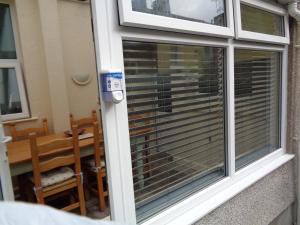 a window with blinds on it with a table at Morwenna Luxury Holiday Apartments in Llandudno