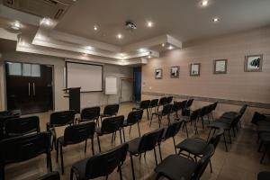 une chambre avec des chaises, un écran de projection et un podium dans l'établissement Hotel Uzhgorod, à Oujhorod