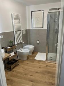 a bathroom with a toilet and a sink and a shower at Pellicceria Guest House in Genova