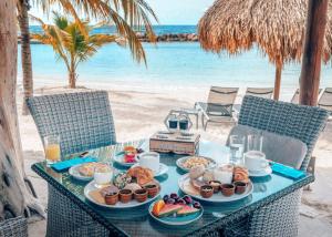 uma mesa com pratos de comida na praia em Curacao Avila Beach Hotel em Willemstad