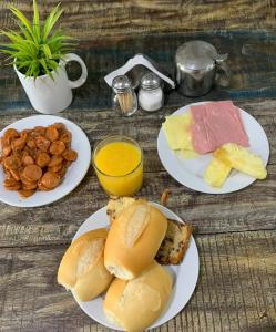 una mesa de madera con platos de comida. en Hotel Casa Blanca, en Campina Grande