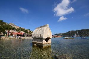 un pilier en pierre dans l'eau d'une masse d'eau dans l'établissement Istlada Taş Ev Apart - Kekova View, à Antalya