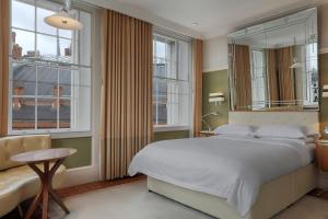 1 dormitorio con 1 cama blanca grande y ventanas en Great Northern Hotel, A Tribute Portfolio Hotel, London en Londres